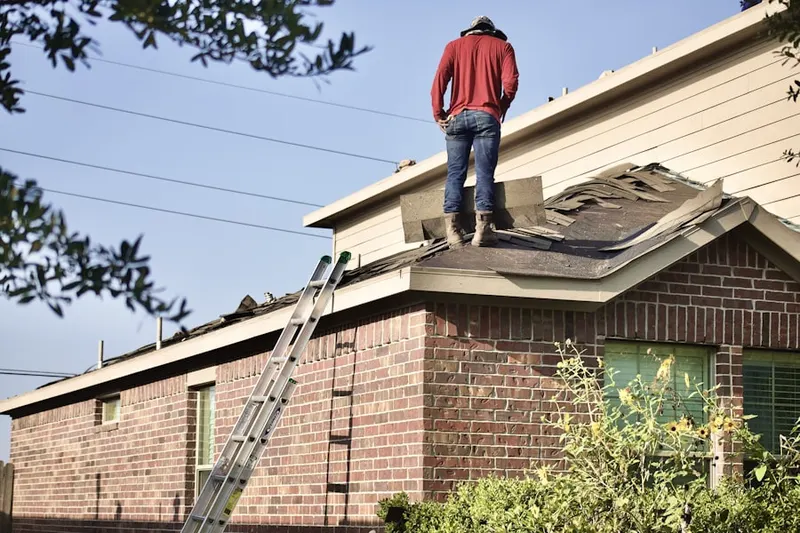 Professional roofer working on a residential roof in Fairport